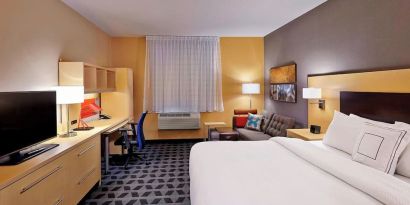 Day use room with TV, work desk and sofa at TownePlace Suites By Marriott London.