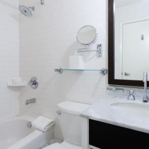 Guest bathroom with shower and tub at Arc The Hotel Ottawa.