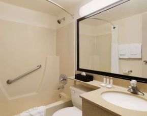 Guest bathroom with tub and free toiletries at Travelodge Edmonton South.