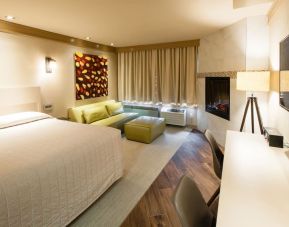 Day use room with TV, work desk, fireplace and private bathroom at Le Chabrol Hotel Et Suites.