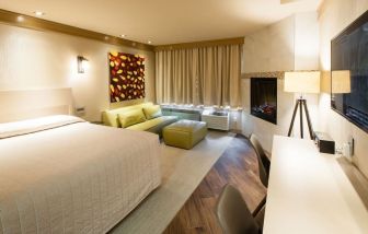 Day use room with TV, work desk, fireplace and private bathroom at Le Chabrol Hotel Et Suites.