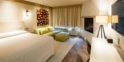 Day use room with TV, work desk, fireplace and private bathroom at Le Chabrol Hotel Et Suites.