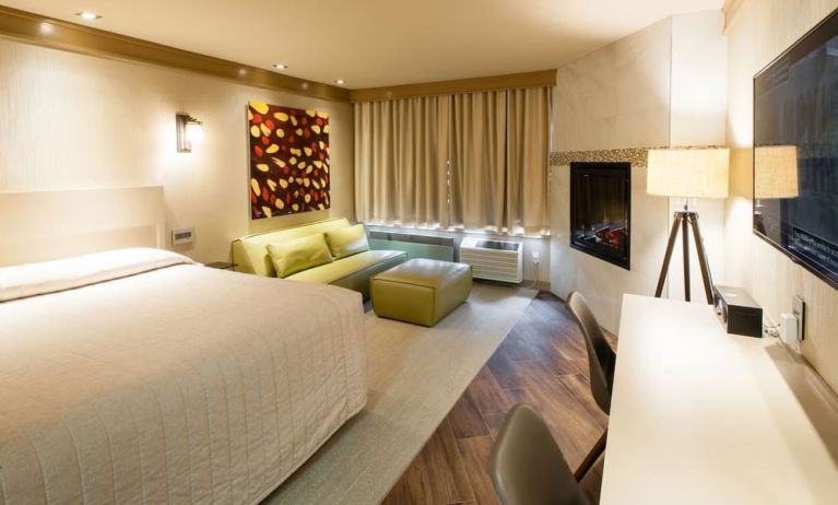 Day use room with TV, work desk, fireplace and private bathroom at Le Chabrol Hotel Et Suites.