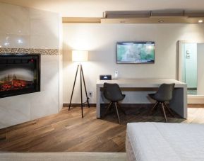 Day use room with TV, work desk, fireplace and private bathroom at Le Chabrol Hotel Et Suites.