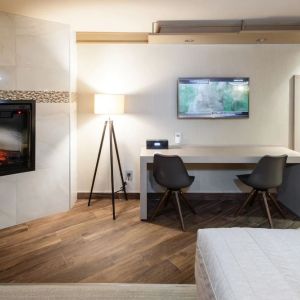 Day use room with TV, work desk, fireplace and private bathroom at Le Chabrol Hotel Et Suites.