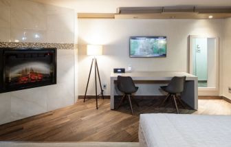 Day use room with TV, work desk, fireplace and private bathroom at Le Chabrol Hotel Et Suites.