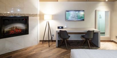 Day use room with TV, work desk, fireplace and private bathroom at Le Chabrol Hotel Et Suites.