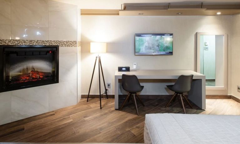 Day use room with TV, work desk, fireplace and private bathroom at Le Chabrol Hotel Et Suites.