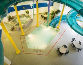 Indoor pool with spiral slide and jacuzzi at Delta Hotel By Marriott Regina.