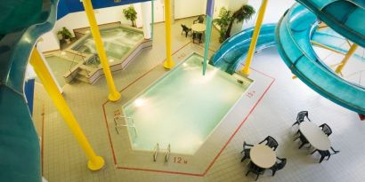 Indoor pool with spiral slide and jacuzzi at Delta Hotel By Marriott Regina.