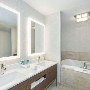 Guest bathroom with tub and free toiletries at Holiday Inn Express & Suites Medicine Hat.