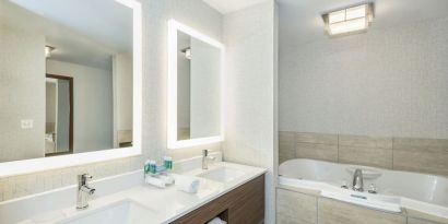 Guest bathroom with tub and free toiletries at Holiday Inn Express & Suites Medicine Hat.