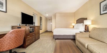 Day use room with TV, work desk and living area at Holiday Inn Lethbridge. 