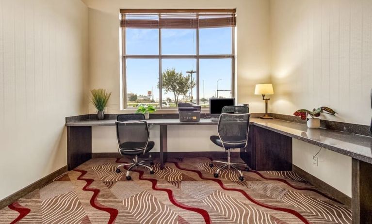 Business center with computer, printer and ergonomic chair at Holiday Inn Lethbridge. 