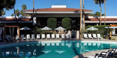 Sun loungers beside outdoor pool at The Scott Resort & Spa.