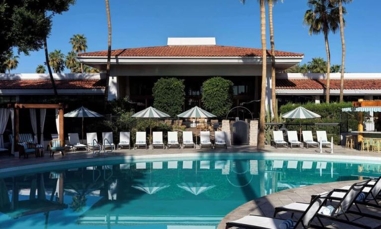 Sun loungers beside outdoor pool at The Scott Resort & Spa.