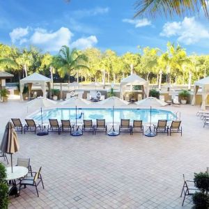 Sun loungers surrounding the pool at Holiday Inn Express & Suites Naples Downtown - 5th Avenue.