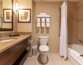 Guest bathroom with tub and shower at Kanata Kelowna And Conference Centre.