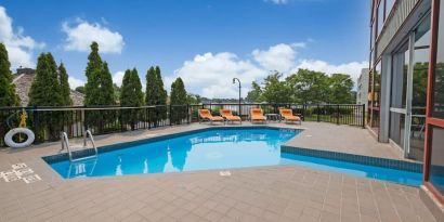 Hotel terrace with outdoor pool and lounge chairs at Holiday Inn Peterborough-Waterfront.