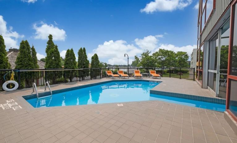 Hotel terrace with outdoor pool and lounge chairs at Holiday Inn Peterborough-Waterfront.