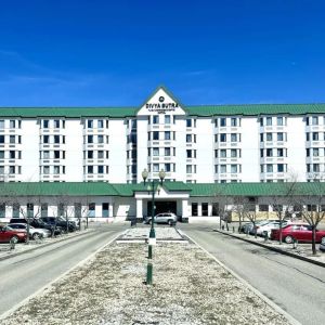 Hotel exterior and parking area at Divya Sutra Plaza & Conference Centre.