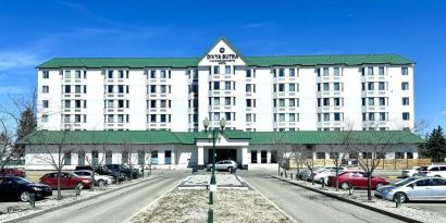 Hotel exterior and parking area at Divya Sutra Plaza & Conference Centre.