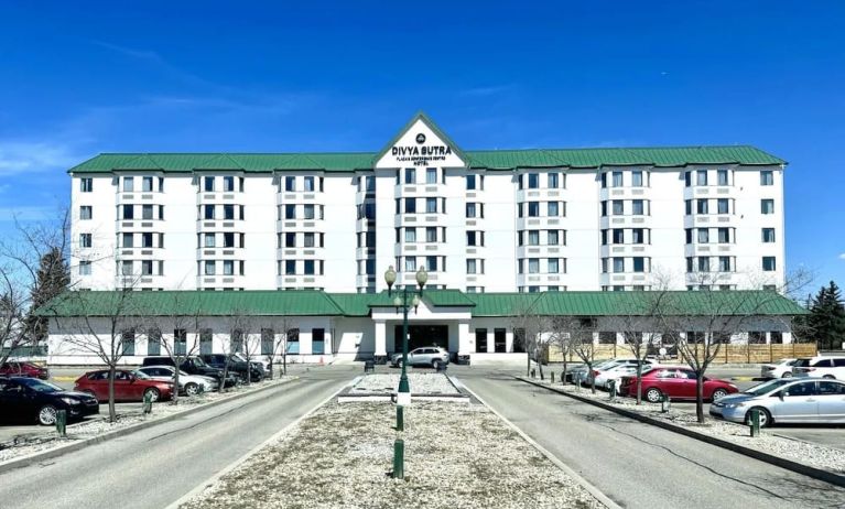 Hotel exterior and parking area at Divya Sutra Plaza & Conference Centre.