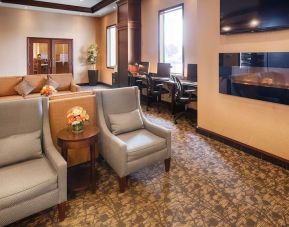 Comfortable lobby lounge with fireplace and workspace with computers, printer and ergonomic chairs at Best Western Plus Winnipeg Airport.