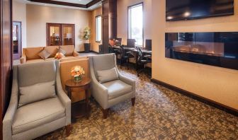 Comfortable lobby lounge with fireplace and workspace with computers, printer and ergonomic chairs at Best Western Plus Winnipeg Airport.