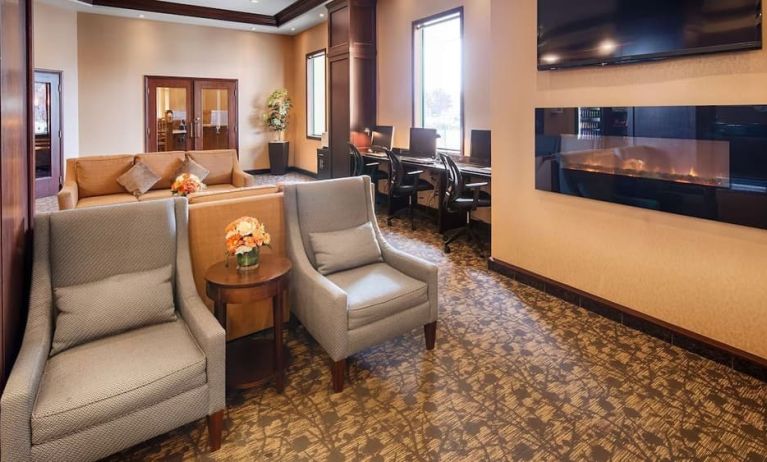 Comfortable lobby lounge with fireplace and workspace with computers, printer and ergonomic chairs at Best Western Plus Winnipeg Airport.