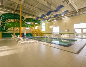 Indoor heated pool with lounge chairs and waterslides at Holiday Inn St. John's Conference Centre.