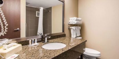 Guest bathroom with shower at Quality Inn Hotel Medicine Hat.