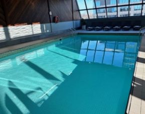 Relaxing indoor pool with lounge chairs at Atlantica Hotel Halifax.