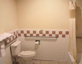 Guest bathroom with shower and tub at Scottish Inn & Suites.