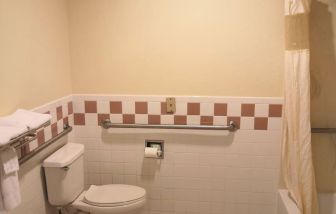 Guest bathroom with shower and tub at Scottish Inn & Suites.