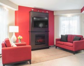 Lobby lounge with TV screen and fireplace at Comfort Inn Fredericton.