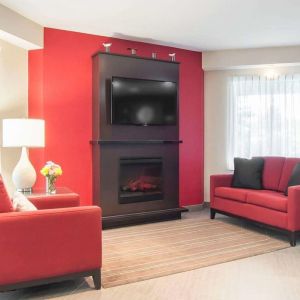 Lobby lounge with TV screen and fireplace at Comfort Inn Fredericton.