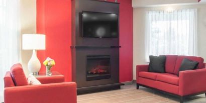 Lobby lounge with TV screen and fireplace at Comfort Inn Fredericton.