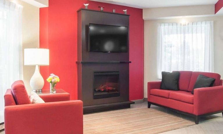 Lobby lounge with TV screen and fireplace at Comfort Inn Fredericton.