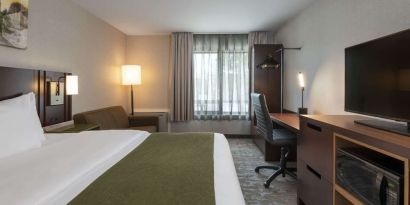 Bright and spacious day use room with TV, work desk and sofa at Comfort Inn Fredericton.