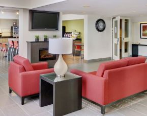 Lobby lounge with TV screen and fireplace at Comfort Inn Sault Ste. Marie.