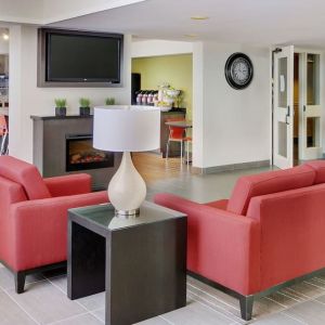 Lobby lounge with TV screen and fireplace at Comfort Inn Sault Ste. Marie.