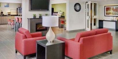 Lobby lounge with TV screen and fireplace at Comfort Inn Sault Ste. Marie.