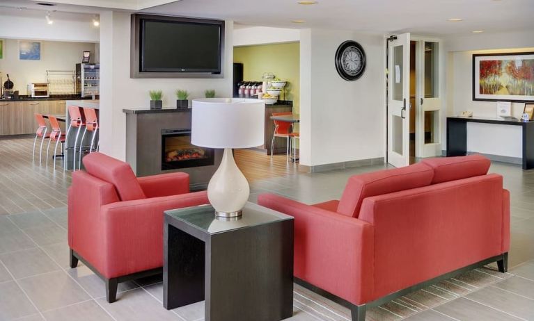 Lobby lounge with TV screen and fireplace at Comfort Inn Sault Ste. Marie.