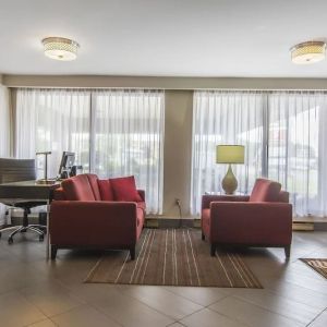 The hotel lobby has comfortable seating, and is brightly lit thanks to large windows.