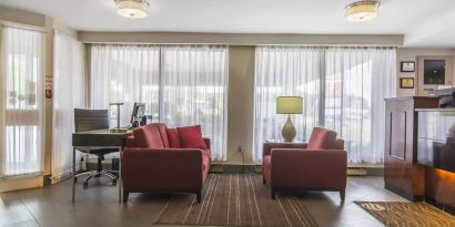 The hotel lobby has comfortable seating, and is brightly lit thanks to large windows.