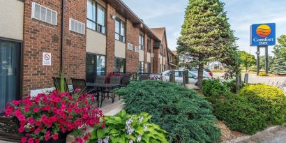 Hotel exterior with beautiful sitting area at Comfort Inn Sault Ste. Marie.