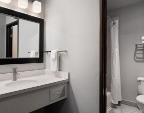 Guest bathroom with shower and tub at Garner By IHG.