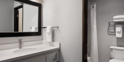 Guest bathroom with shower and tub at Garner By IHG.