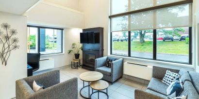 Stylish lobby lounge with TV screen, fireplace and comfortable seating at Comfort Inn Charlottetown.